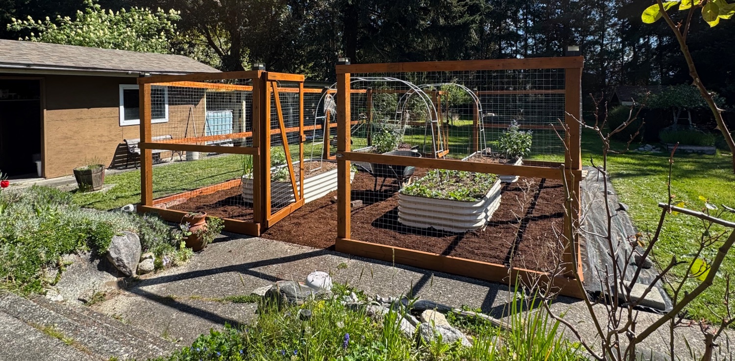 An enclosed gardening/farming area in the middle of a yard.